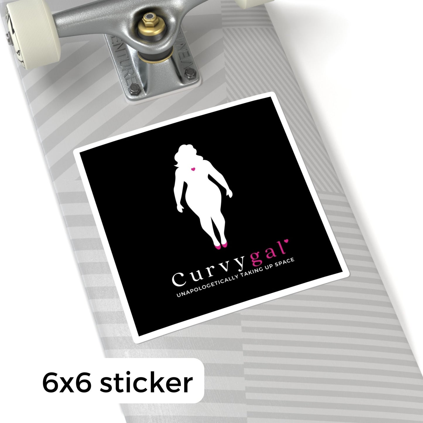 A black vinyl sticker on a skateboard that reads Curvygal: Unapologetically Taking Up Space in black and pink font underneath the silhouette of a curvy feminine body with a pink heart in the center of the chest.