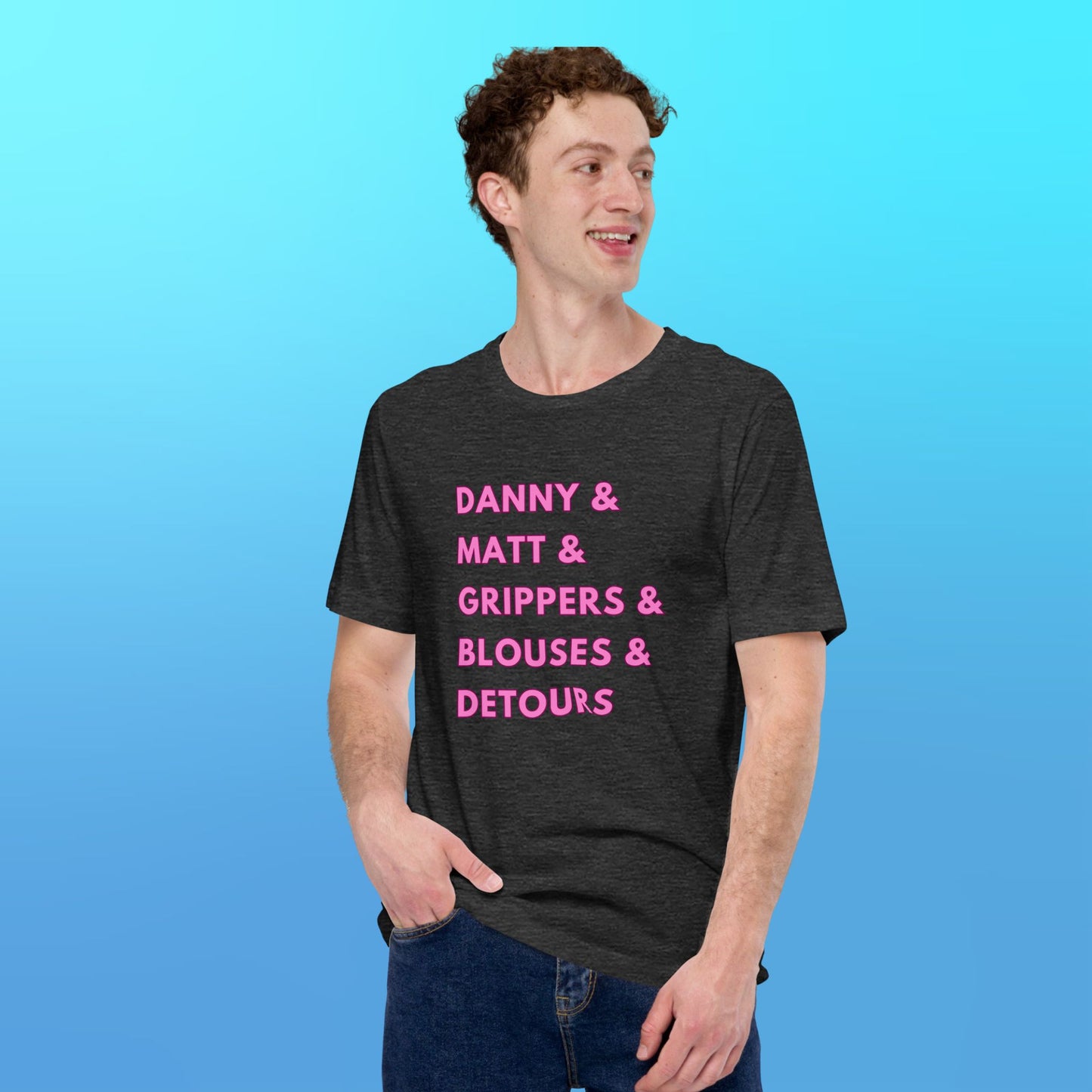 A person wearing a heather grey T-shirt that reads "Danny & Matt & Grippers& Blouses & Detours" in pink capital letters