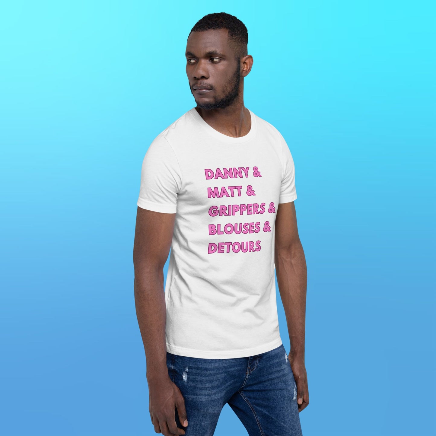 A person wearing a white T-shirt that reads "Danny & Matt & Grippers& Blouses & Detours" in pink capital letters